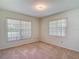 Neutral bedroom offering natural light from two windows, ideal for relaxation and rest at 1914 Henley Rd, Lutz, FL 33558