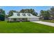 Charming home with a light green roof, lush front lawn and a spacious three car garage at 1914 Henley Rd, Lutz, FL 33558