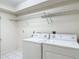 Clean laundry room with modern washer and dryer, tile floor, and upper shelving at 1914 Henley Rd, Lutz, FL 33558