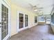 Extended, screened-in lanai with tiled floors, ceiling fans, and multiple access doors at 1914 Henley Rd, Lutz, FL 33558