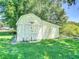 A charming, rustic shed with weathered yellow siding, offering a classic, functional outdoor storage solution at 1914 Henley Rd, Lutz, FL 33558