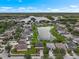 A vibrant neighborhood surrounds a scenic lake in this aerial view, under a sunny, partly cloudy sky at 1933 Fruitridge St, Brandon, FL 33510