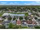 Aerial view of a community with a lake surrounded by many homes, lush trees, and blue sky at 1933 Fruitridge St, Brandon, FL 33510