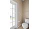 Bright bathroom featuring a toilet, tiled floors, and frosted window at 1933 Fruitridge St, Brandon, FL 33510