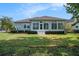 Well-manicured backyard with lush grass, manicured hedges, and a screened-in porch at 212 Shell Creek Ct, Apollo Beach, FL 33572