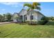 Attractive single-story home showcasing a well-manicured lawn and verdant palm trees at 212 Shell Creek Ct, Apollo Beach, FL 33572