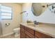Cozy bathroom with warm wood vanity and a framed round mirror at 2204 78Th W St, Bradenton, FL 34209