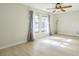 Sunlit bedroom boasts neutral walls, a ceiling fan, and beautiful, light wood-look floors at 2204 78Th W St, Bradenton, FL 34209