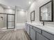 Modern bathroom with dual vanity sinks, gray cabinets, and a walk-in shower with a glass door at 2330 Hiers Rd, Dover, FL 33527