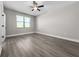 Serene bedroom featuring neutral walls, wood flooring, a ceiling fan, and a large window at 2330 Hiers Rd, Dover, FL 33527