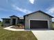 Charming single-story home with a dark garage door, complemented by a manicured lawn and blue sky at 2330 Hiers Rd, Dover, FL 33527