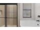 Modern bathroom featuring a shower with glass doors and a free standing tub under a horizontal window at 2402 Hiers Rd, Dover, FL 33527