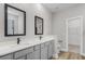 Modern bathroom featuring double vanity sinks, square mirrors, and gray cabinets at 2402 Hiers Rd, Dover, FL 33527