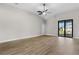 Bright open-plan living area with wood floors, ceiling fan, and sliding glass doors to the backyard at 2414 Hiers Rd, Dover, FL 33527