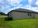 View of the home's backyard featuring a well-maintained lawn and privacy fence at 24815 Lambrusco Loop, Lutz, FL 33559