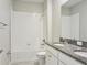 Bathroom with a granite vanity, a soaking tub with shower, and a commode at 24815 Lambrusco Loop, Lutz, FL 33559