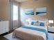 Bedroom with a bed, a dresser, matching nightstands, and beach-themed paintings at 24815 Lambrusco Loop, Lutz, FL 33559