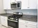 Close-up of a stainless steel gas range and granite countertops with white cabinets at 24815 Lambrusco Loop, Lutz, FL 33559