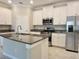 Modern kitchen featuring white cabinets, stainless steel appliances, and a granite island at 24815 Lambrusco Loop, Lutz, FL 33559