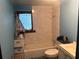 Small bathroom with tiled shower, white fixtures, and a window at 25425 Olympia Rd, Brooksville, FL 34601