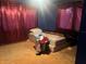 Bedroom with a double mattress on the floor, bright lighting, and magenta curtains at 25425 Olympia Rd, Brooksville, FL 34601