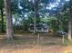 View of house exterior with overgrown yard and mature trees at 25425 Olympia Rd, Brooksville, FL 34601