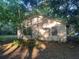 View of house exterior with overgrown yard and mature shade trees at 25425 Olympia Rd, Brooksville, FL 34601