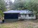 Side view of home with metal roof, screened in porch and mature trees to keep it shady and cool at 25425 Olympia Rd, Brooksville, FL 34601