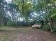 Exterior view featuring a car and partially collapsed building in overgrown yard at 25425 Olympia Rd, Brooksville, FL 34601
