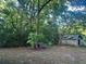 View of a small building with overgrown yard and mature trees at 25425 Olympia Rd, Brooksville, FL 34601