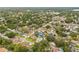 This is an aerial view of a home nestled in a lush, green residential neighborhood with calm streets at 2554 Lake Ellen Cir, Tampa, FL 33618