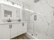 Modern bathroom features dual sinks, wood-look flooring, and a glass-enclosed shower at 2554 Lake Ellen Cir, Tampa, FL 33618