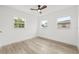 Bright bedroom featuring wood-look floors, three windows, and fresh paint at 2554 Lake Ellen Cir, Tampa, FL 33618