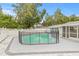 Backyard view of a pool with a safety fence, surrounded by well-maintained landscaping and an enclosed porch at 2554 Lake Ellen Cir, Tampa, FL 33618