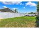 Spacious backyard featuring a white fence, lush green grass, and an inviting outdoor seating area at 2708 Dolphin Watch Ct, Holiday, FL 34691