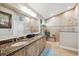 Bathroom features a double sink, granite countertops, tiled walk-in shower, and natural light at 2708 Dolphin Watch Ct, Holiday, FL 34691