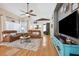 Bright living room with hardwood floors, a ceiling fan, two leather sofas and a large TV at 2708 Dolphin Watch Ct, Holiday, FL 34691