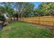 Fenced backyard with grass, stepping stones, and trees provides a private outdoor space at 300 33Rd N Ave, St Petersburg, FL 33704