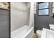 Bathroom featuring a tub with a shower, neutral colored tile, and wainscotting at 300 33Rd N Ave, St Petersburg, FL 33704