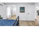 Bright bedroom with wood-look floors and doorways leading to a hallway and kitchen at 300 33Rd N Ave, St Petersburg, FL 33704