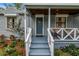 Inviting front porch with seating, plants, and blue painted steps and front door at 300 33Rd N Ave, St Petersburg, FL 33704