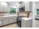 Modern kitchen with gray cabinets, stainless steel appliances, quartz countertops, and tiled backsplash at 300 33Rd N Ave, St Petersburg, FL 33704