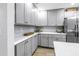 Close-up view of the kitchen's gray cabinetry, white countertops, stainless steel refrigerator, and modern backsplash at 300 33Rd N Ave, St Petersburg, FL 33704