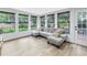 Bright sunroom with large windows, a comfortable sectional sofa, and access to an outdoor patio at 300 33Rd N Ave, St Petersburg, FL 33704