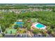 Beautiful aerial view showcasing the community pool, tennis courts, and lush green surroundings at 30918 Burleigh Dr, Wesley Chapel, FL 33543
