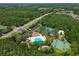 Overhead view featuring a community pool, basketball court, and tennis courts, surrounded by trees at 30918 Burleigh Dr, Wesley Chapel, FL 33543