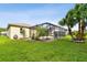 Picturesque backyard featuring a screened patio, palm trees, and beautiful landscaping, ideal for relaxation at 30918 Burleigh Dr, Wesley Chapel, FL 33543