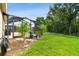 Lush backyard showcasing the screened patio, decorative plants, and a well-manicured lawn at 30918 Burleigh Dr, Wesley Chapel, FL 33543