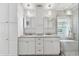 Bright bathroom with double sink vanity, granite countertops, stylish mirror cabinets, and tiled walk-in shower at 30918 Burleigh Dr, Wesley Chapel, FL 33543