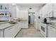 Contemporary kitchen featuring stainless steel appliances, granite countertops, white cabinets, and sleek tile backsplash at 30918 Burleigh Dr, Wesley Chapel, FL 33543